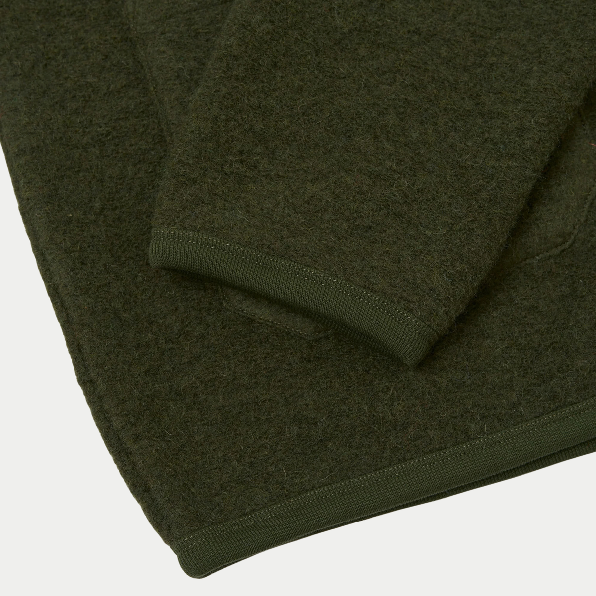 Poignet et ourlet du cardigan en Wool Fleece vert olive bordés de côtes fines en coton