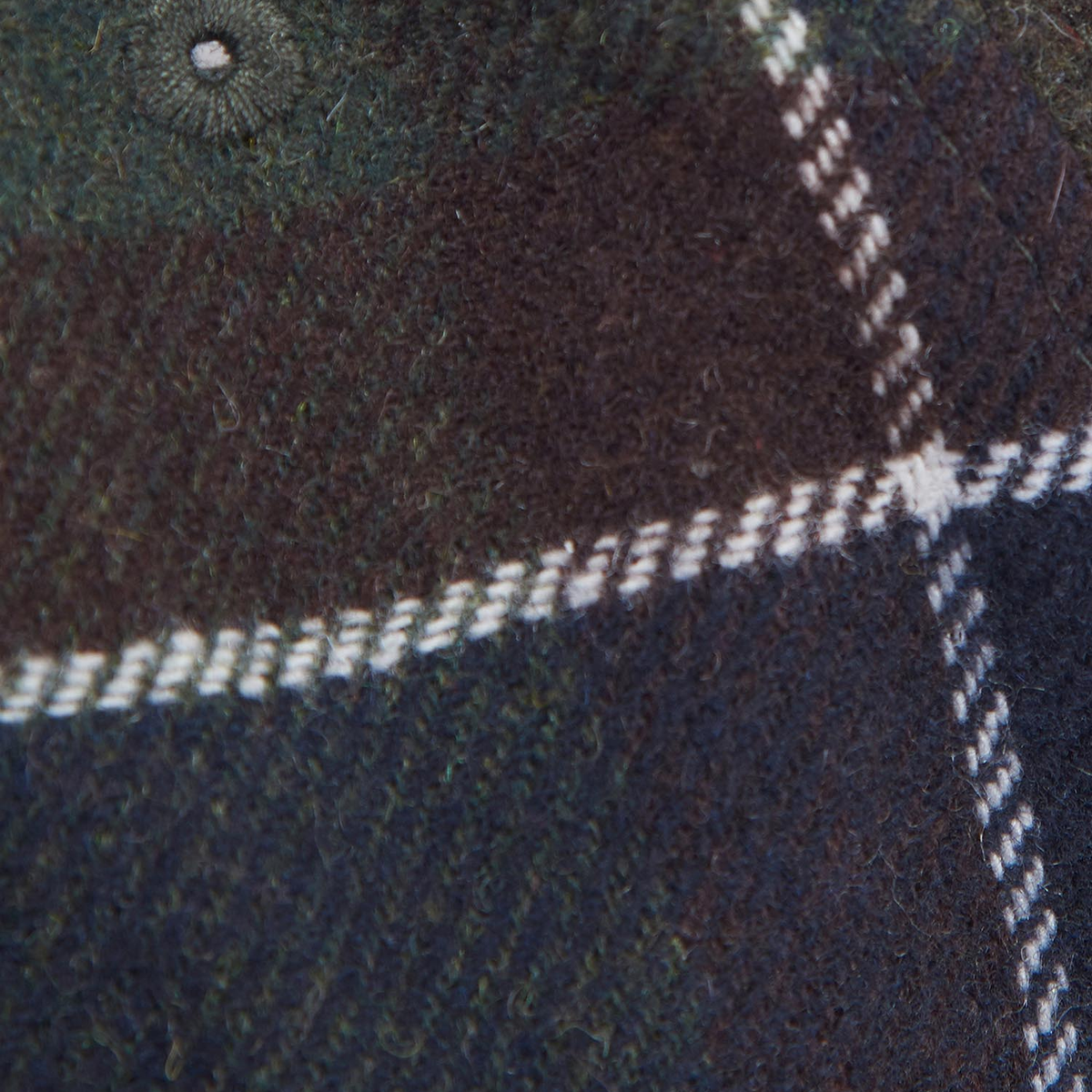 Gros plan du tissu toucher laine Classic Tartan de la casquette Galingale Barbour et bouton de calotte