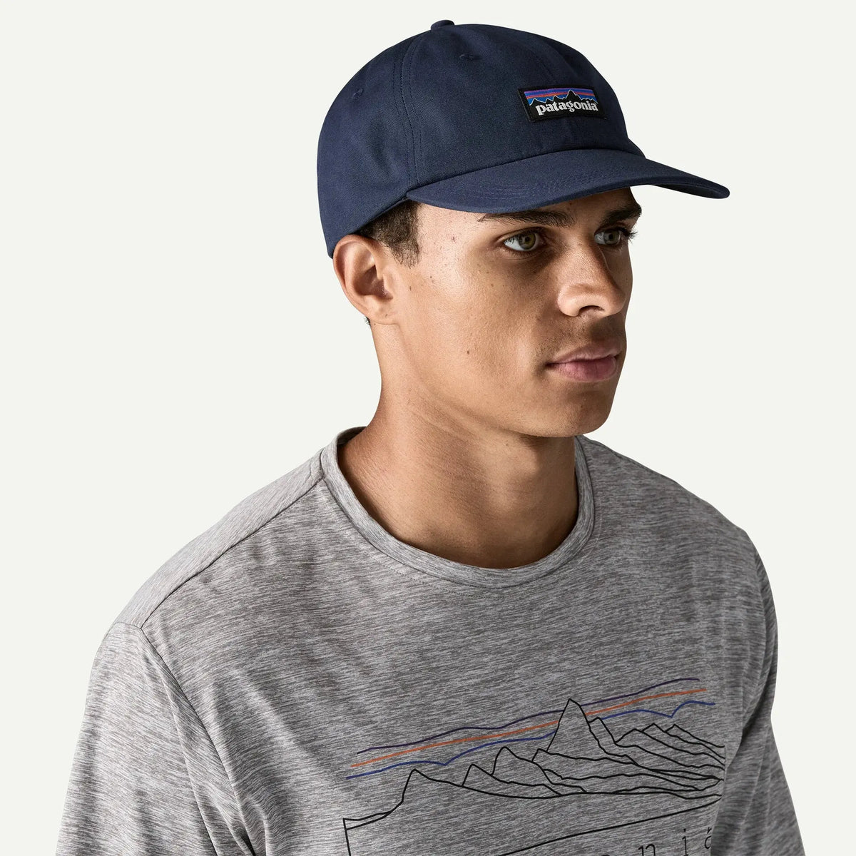 Casquette P-6 Label Trad bleu marine Patagonia portée, profil droit, visière bordée NetPlus et étiquette P-6