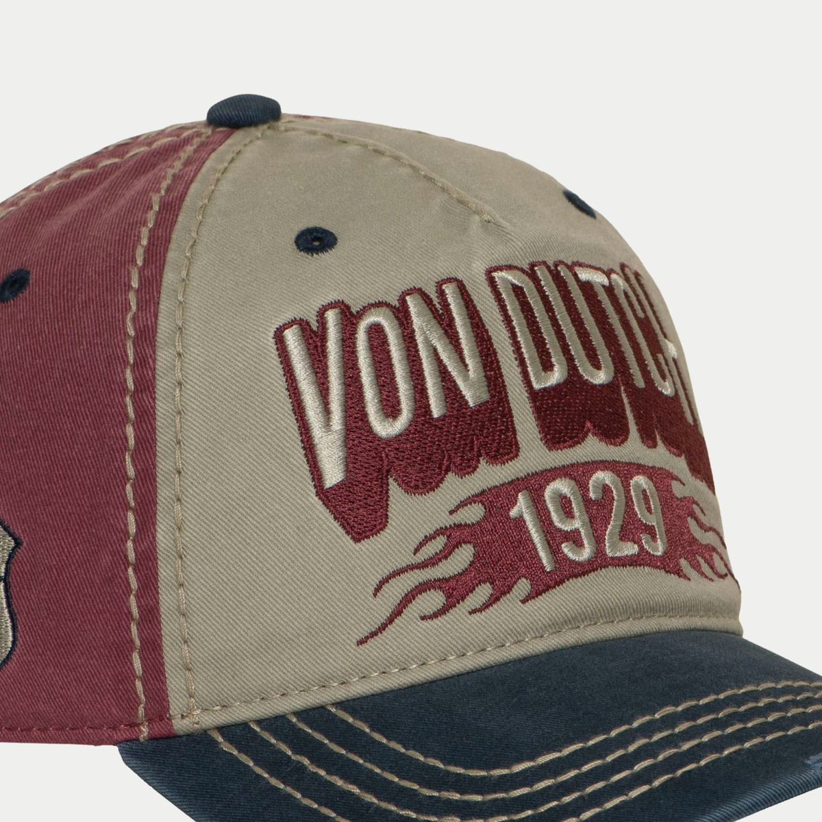Gros plan sur la broderie Von Dutch 1929 et ses flammes bordeaux, casquette Retro beige