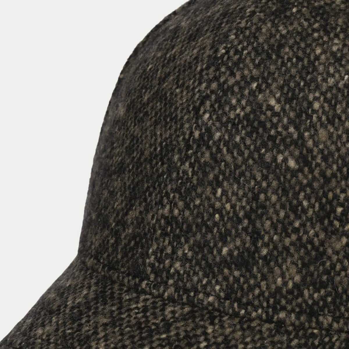 Gros plan sur les flammes claires du tweed Donegal anthracite, façade de la casquette baseball Stetson