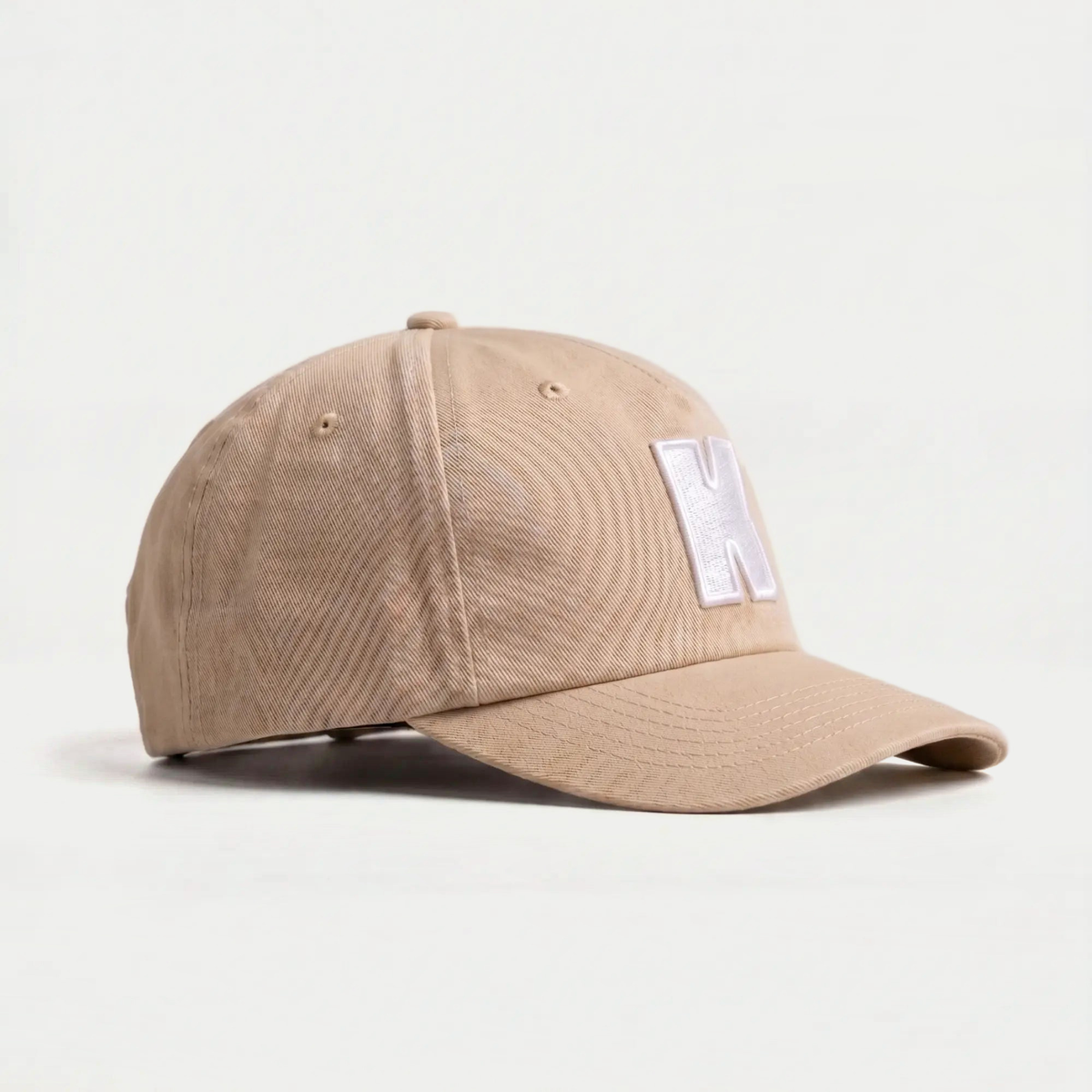 Casquette Klubb beige sable de trois quarts : sergé de coton, œillets d'aération et bouton de sommet assorti