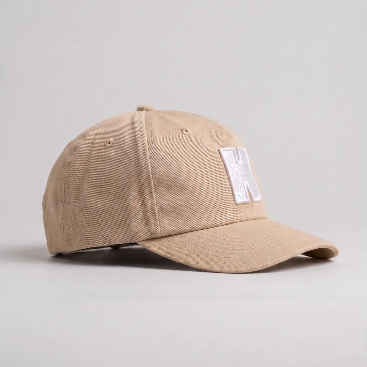 Casquette Klubb beige sable de trois quarts : sergé de coton, œillets d'aération et bouton de sommet assorti