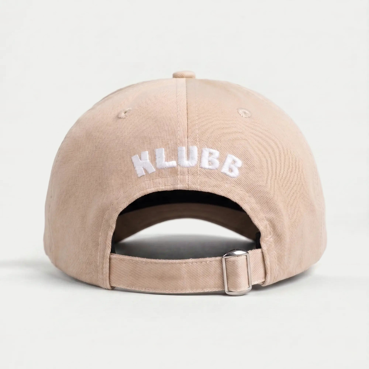 Dos de la casquette Klubb beige sable : logo KLUBB blanc brodé en arc, sangle beige et boucle métal argentée
