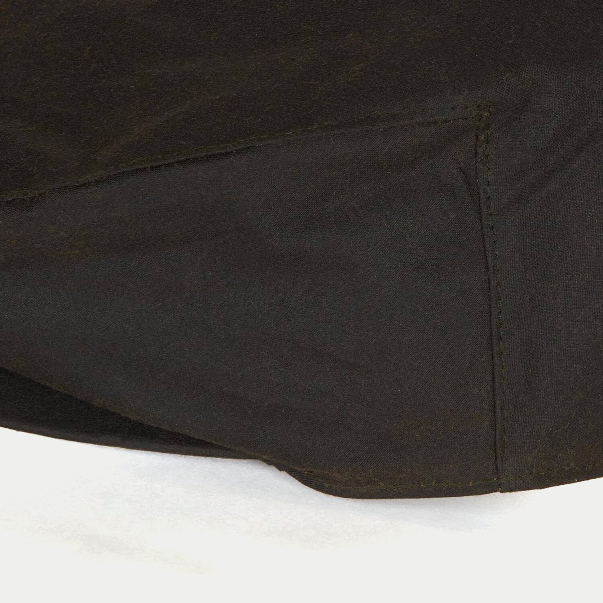 Casquette plate cirée olive Barbour - gros plan sur les coutures de la calotte en coton ciré