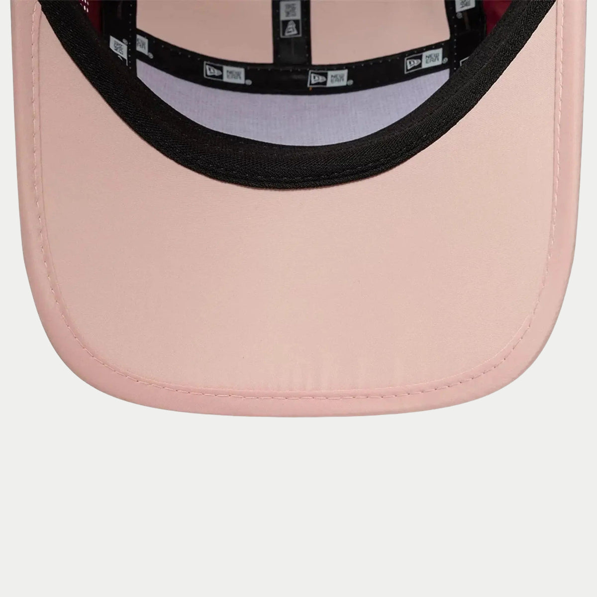 Dessous de la visière rose pâle de la casquette Runner New Era rouge foncé