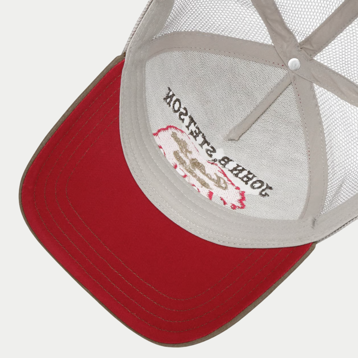 Dessous de la casquette trucker Bear Stetson beige : visière rouge surpiquée, broderie de l'ours visible à l'intérieur
