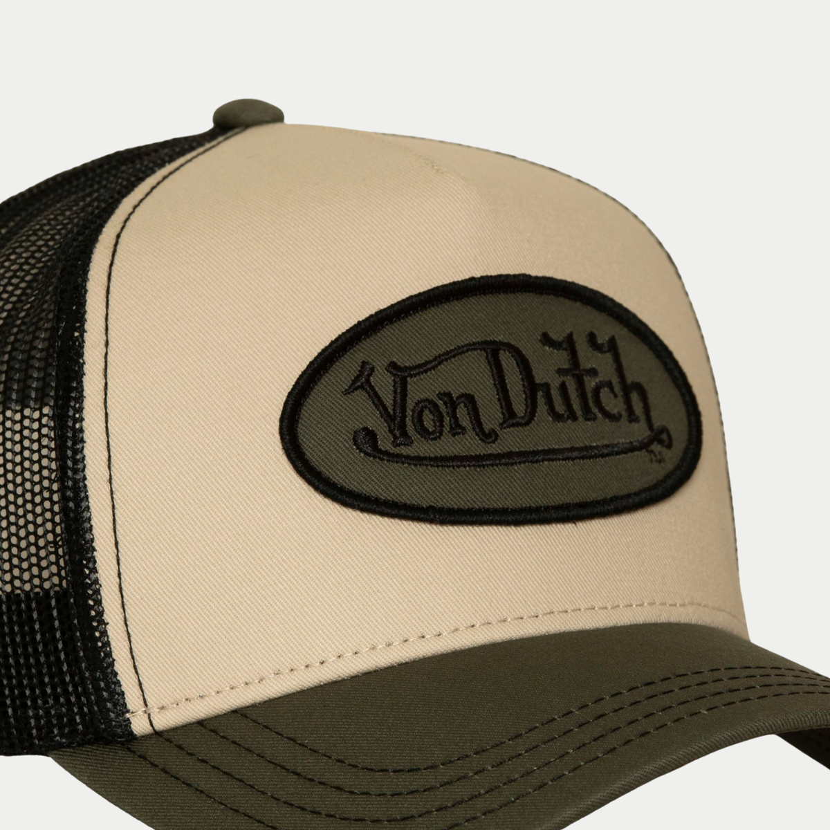 Gros plan sur l'écusson Von Dutch kaki brodé noir de la casquette trucker Classic beige