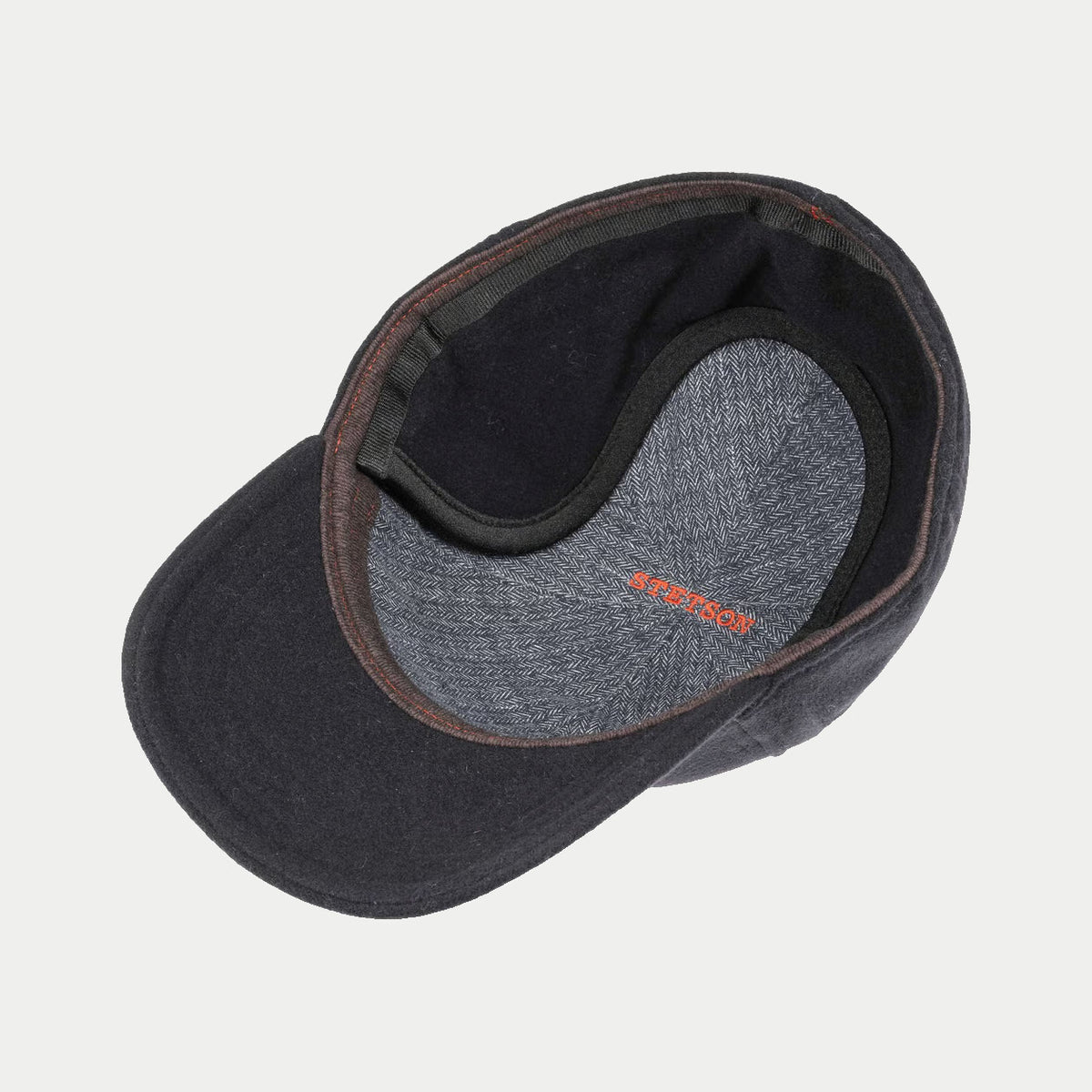Intérieur de la casquette Vaby bleu marine : doublure à chevrons gris-bleu, logo Stetson orange, cache-oreilles