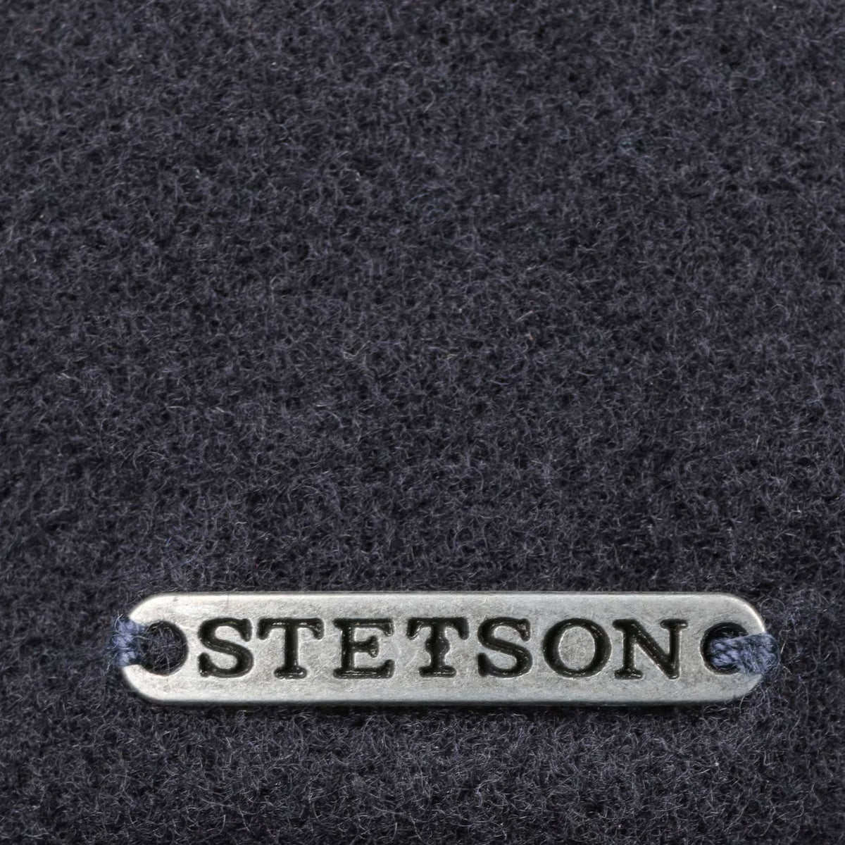 Plaque métal Stetson sur la laine bleu marine de la casquette Vaby, gros plan