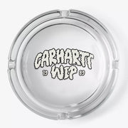 Cendrier rond en verre transparent vu de dessus, lettrage nuage crème 1989 au fond et quatre encoches