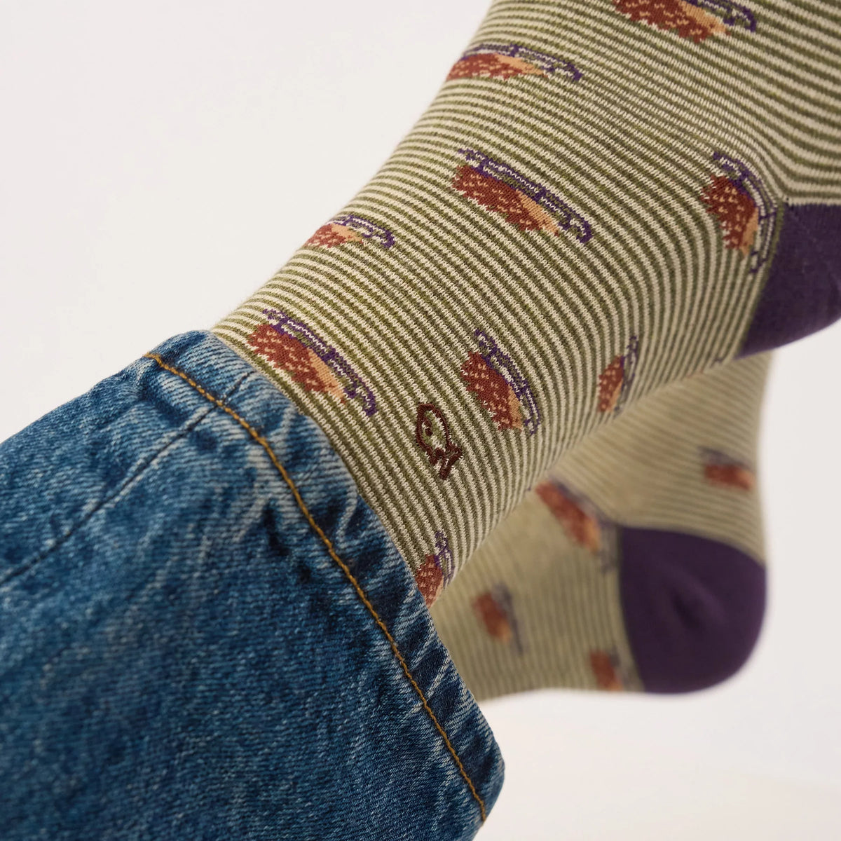 Gros plan du motif hérissons sur luge et du logo poisson brodé des chaussettes BillyBelt rayées kaki