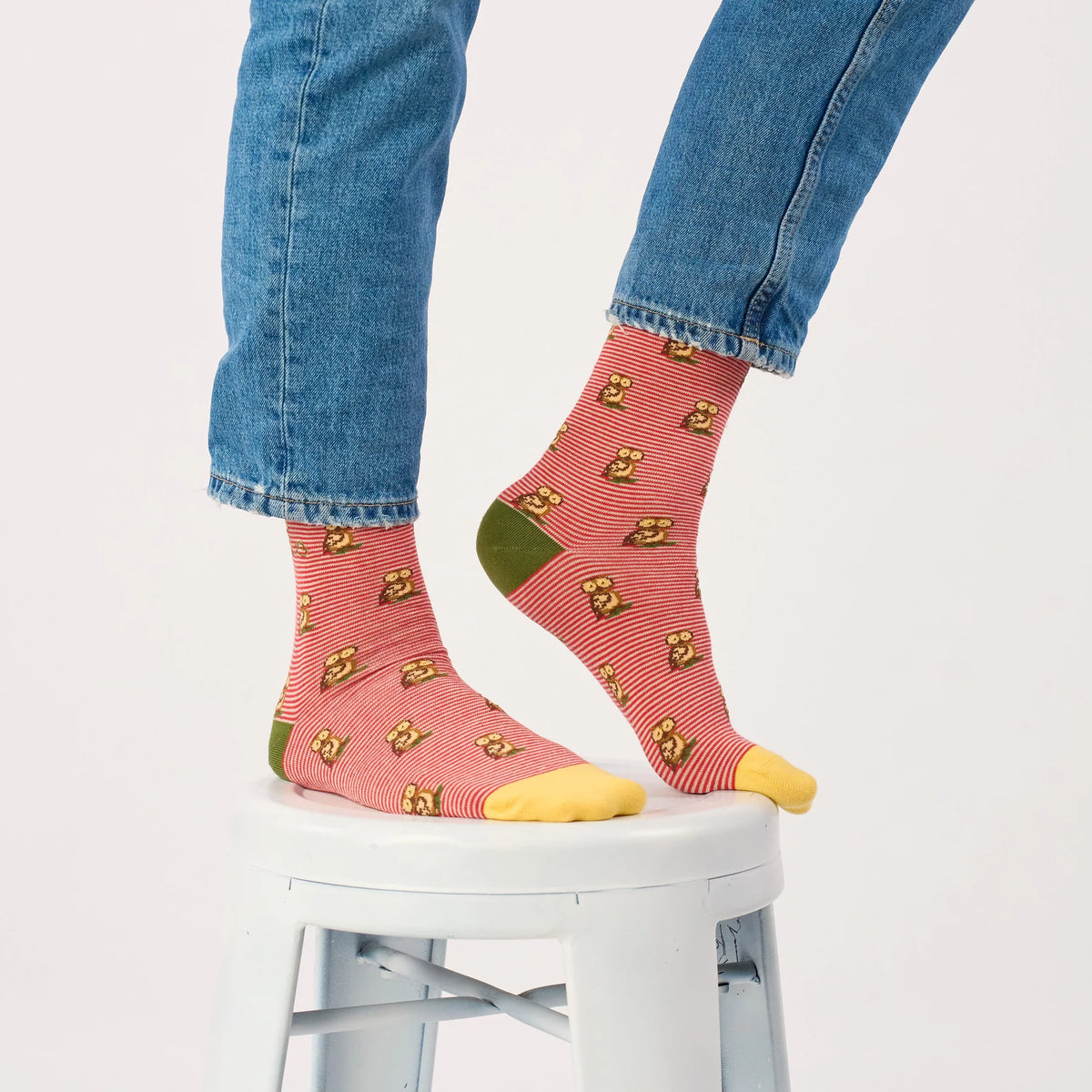 Chaussettes Hibou BillyBelt portées sous un jean bleu, pied levé montrant le talon vert olive et la pointe jaune