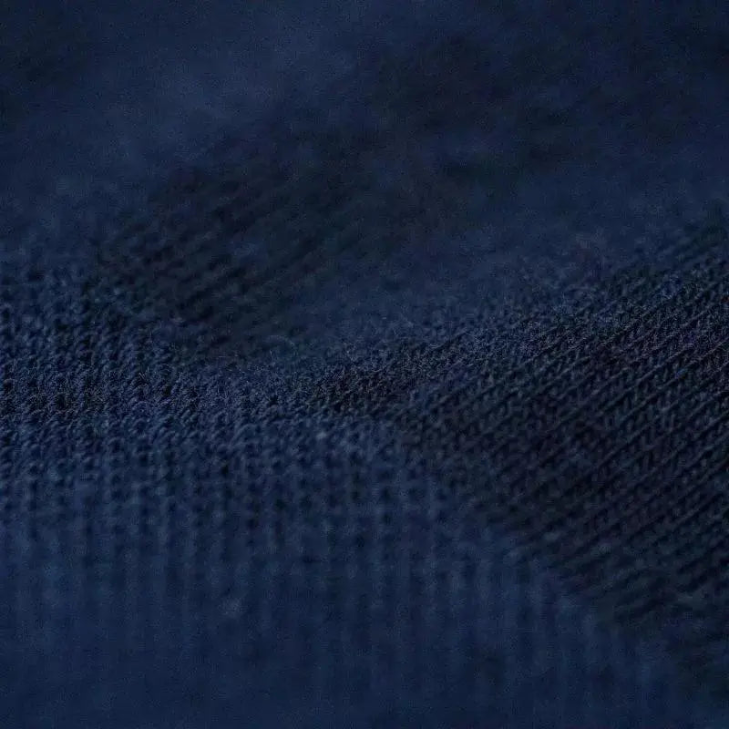Macro sur la maille Bleu Marine : fines côtes verticales et coton lisse, sans motif ni contraste de couleur