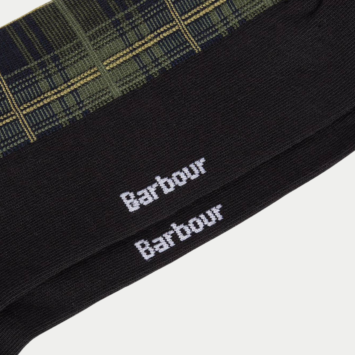 Gros plan sur les plantes de pied des chaussettes Blyth Olive Night, logo Barbour tricoté en blanc sur la maille noire