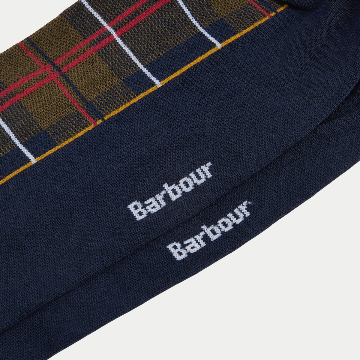 Détail macro des chaussettes Blyth Tartan Olive : plantes de pied bleu marine et logo Barbour tricoté en blanc