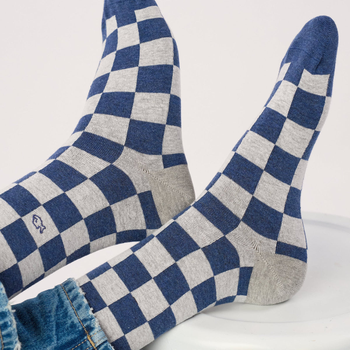 Gros plan du damier bleu et gris clair, du talon gris chiné et de la pointe bleue des chaussettes Tsukuba