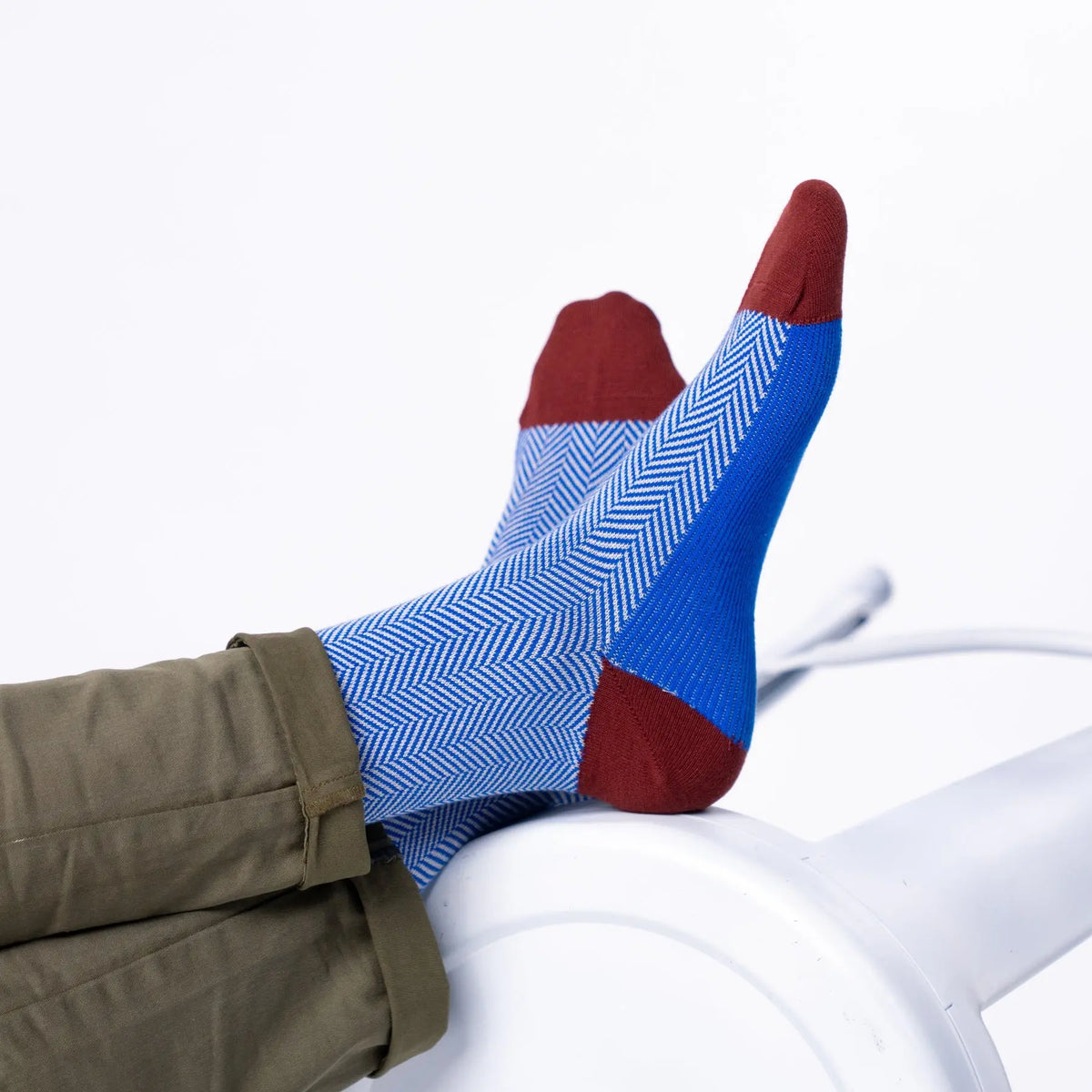Chaussettes à chevrons bleu roi vues pieds relevés, pointes bordeaux et large bande bleu vif sous le pied