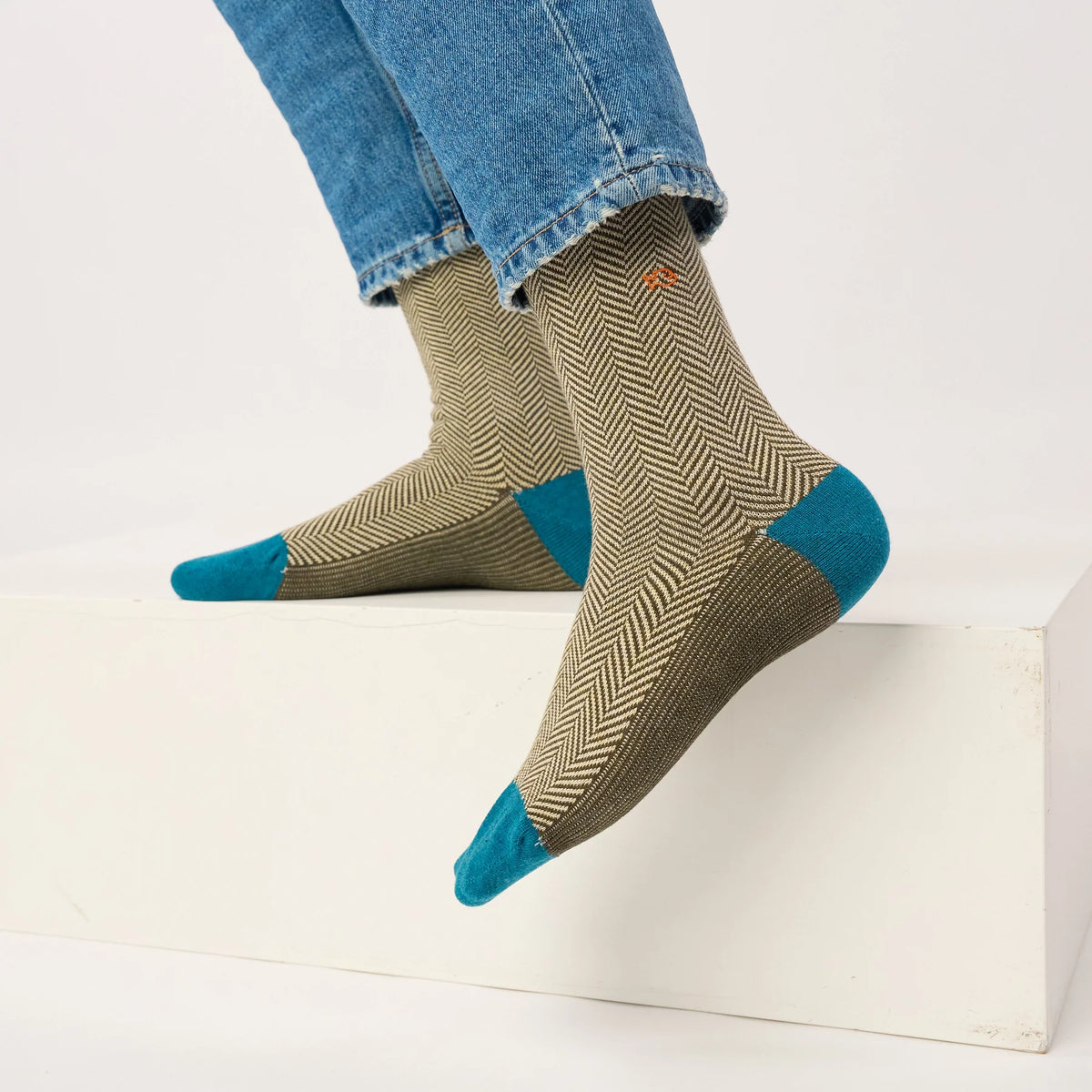 Chaussettes à chevrons Sauge Chiné portées sous un jean, pieds en l'air, talons et pointes bleu canard