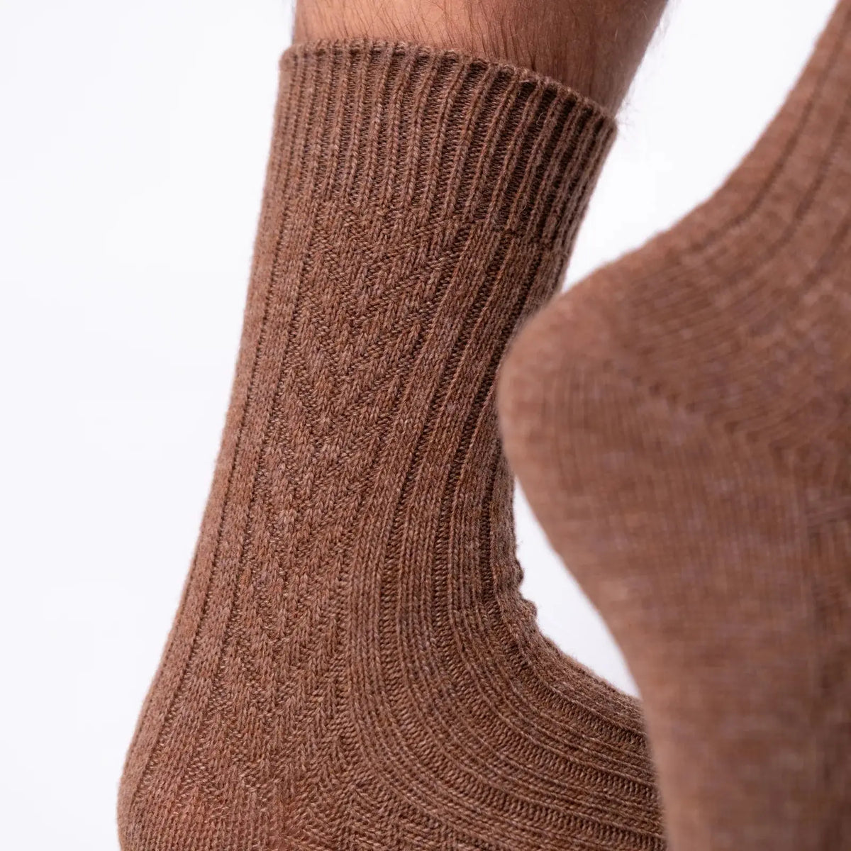 Détail du coup de pied en laine marron chinée, colonnes de côtes et léger halo duveteux de la maille