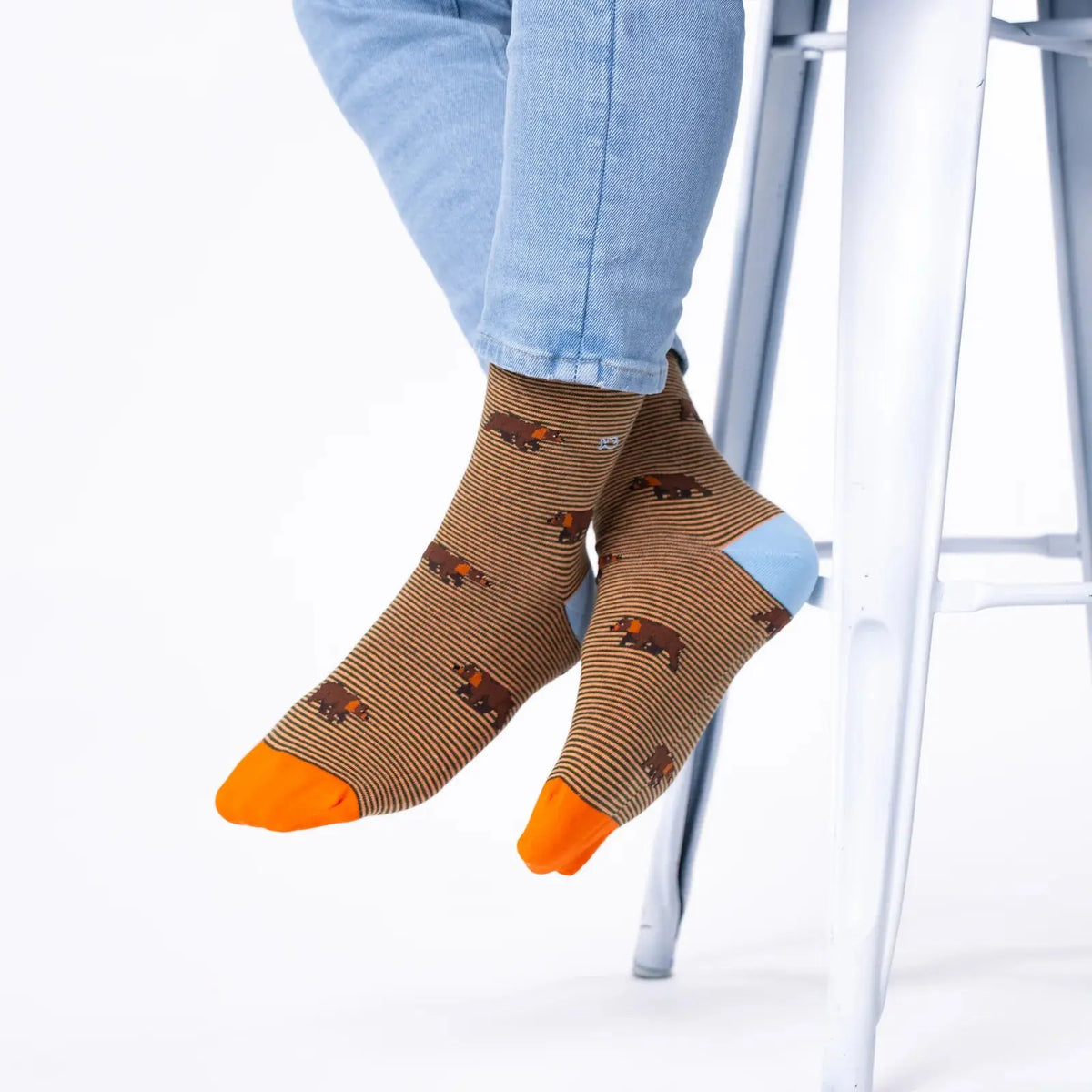 Chaussettes Ours BillyBelt marron portées jambes croisées, talons bleu ciel et pointes orange