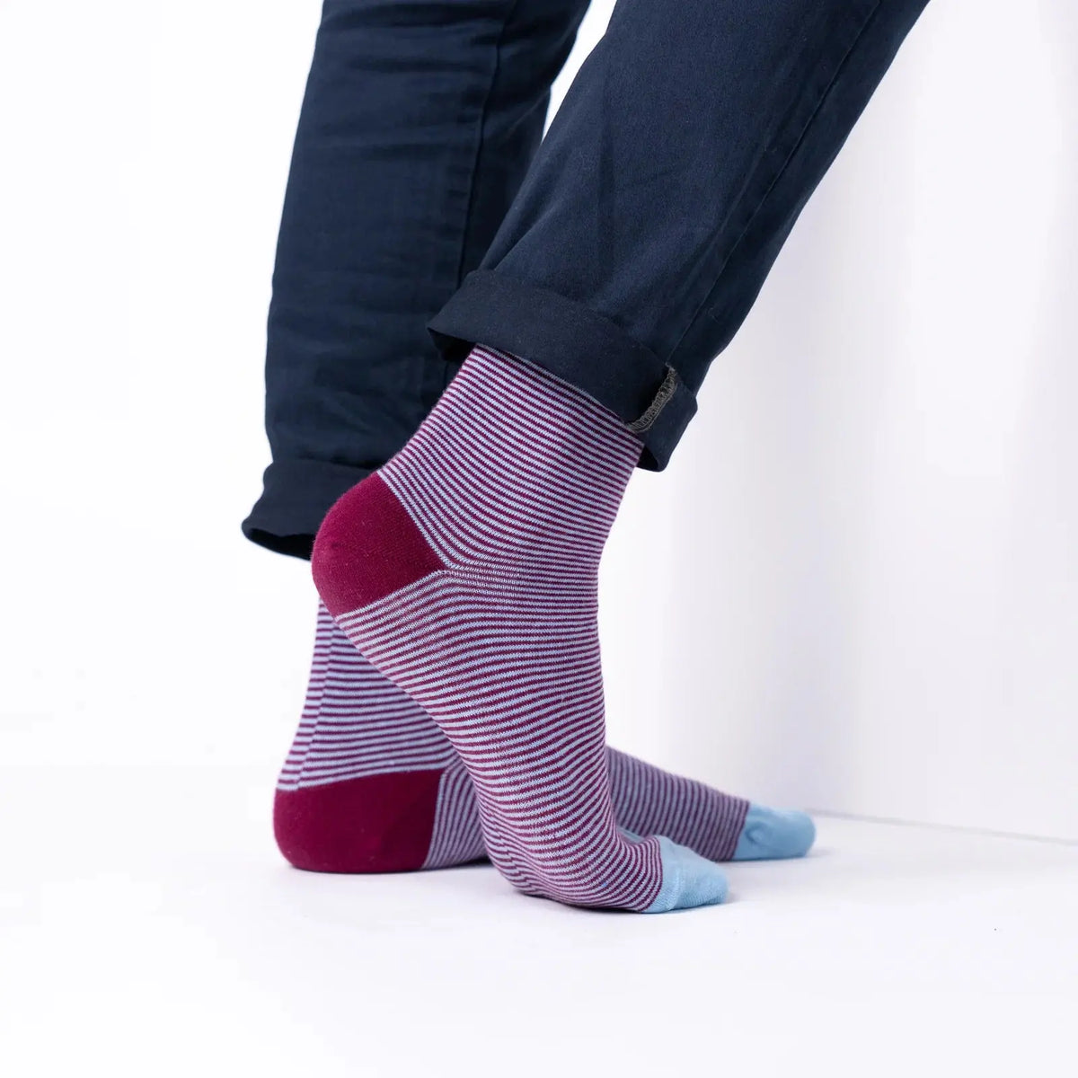 Tige mi-mollet rayée bordeaux et lilas vue de profil sous un revers de pantalon, talon bordeaux marqué.