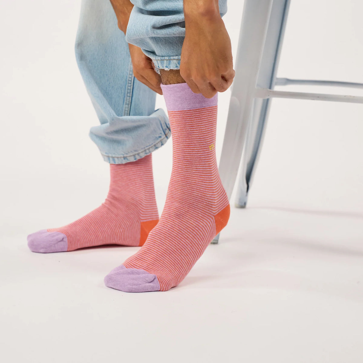 Paire de chaussettes rayées orange et lilas BillyBelt portées de face, revers lilas remonté sous le jean