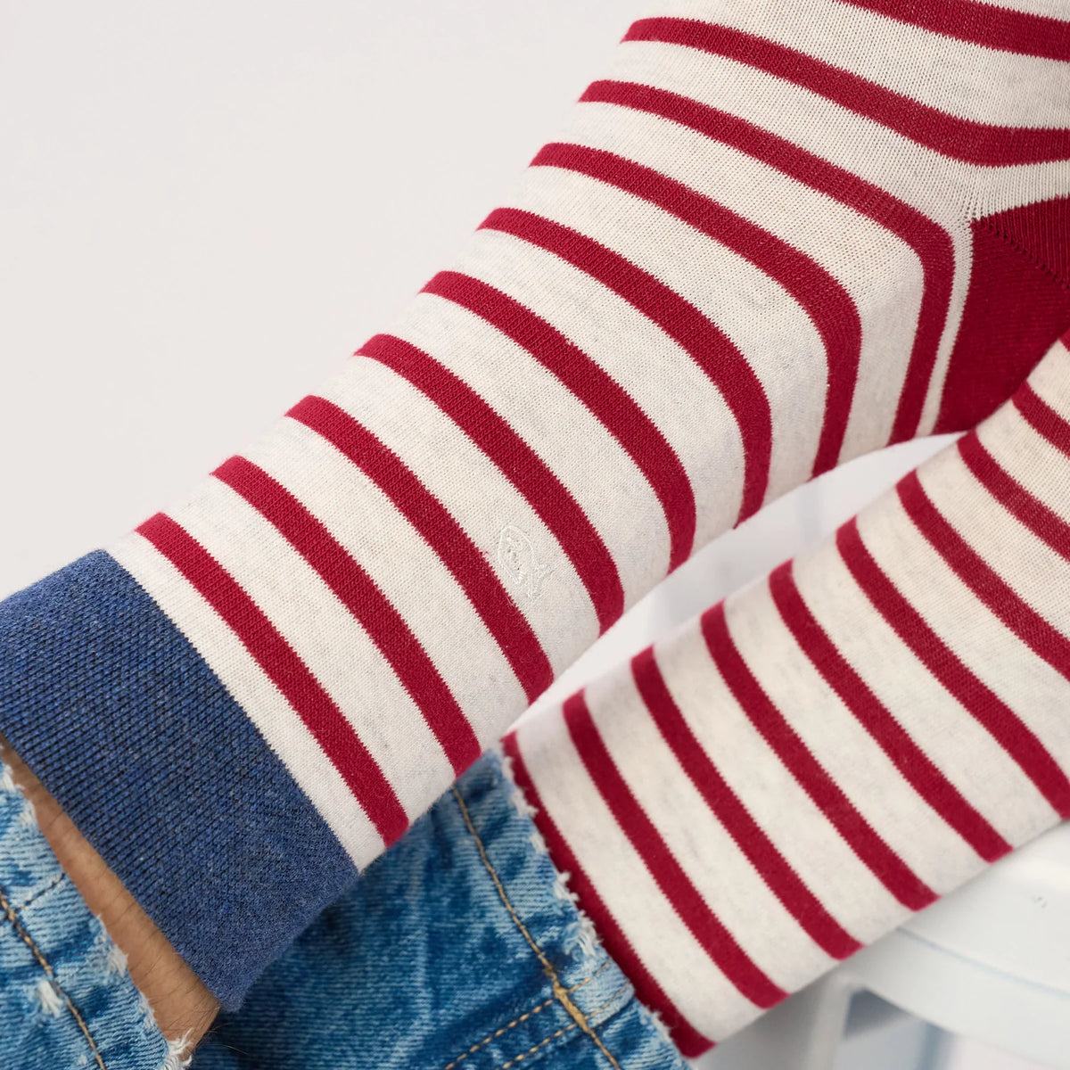 Gros plan sur les rayures bordeaux, le fond gris chiné et le revers bleu des chaussettes BillyBelt, logo brodé