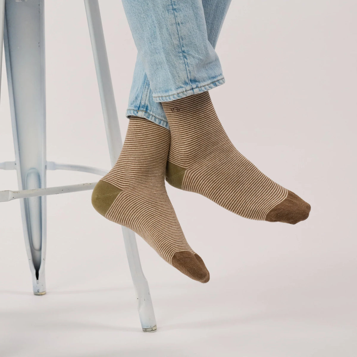 Paire de chaussettes rayées marron et écru BillyBelt portées avec un jean clair, jambes croisées