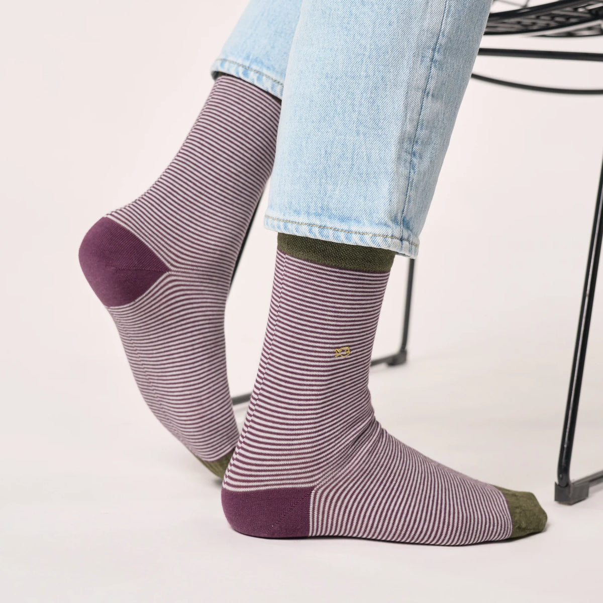Chaussettes Rayures Violet & Kaki portées sous un jean clair, vue sur le talon prune et le logo brodé
