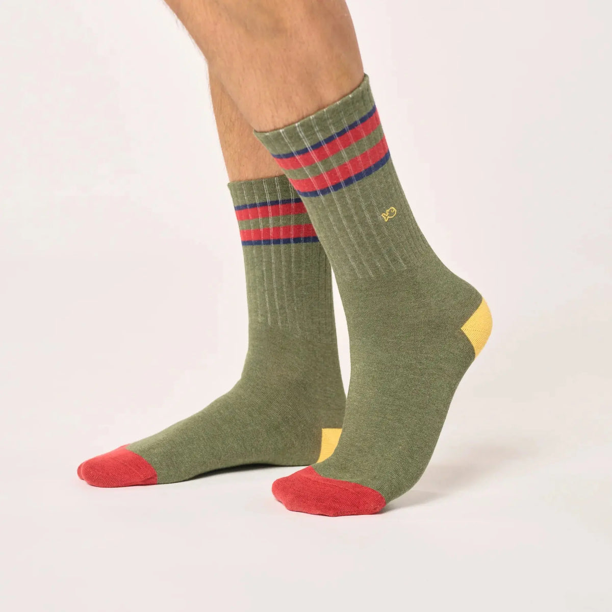 Chaussettes kaki côtelées portées de profil, bandes rouge et Bleu Marine en haut de tige, pointe rouge.