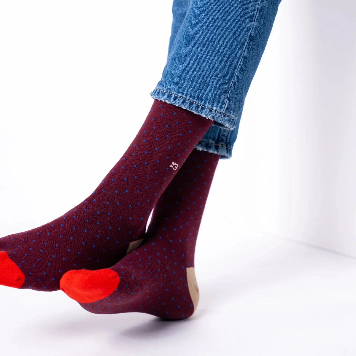 Chaussettes bordeaux à micro-carrés bleu roi vues en mouvement, pointes rouge vif et talons sable.