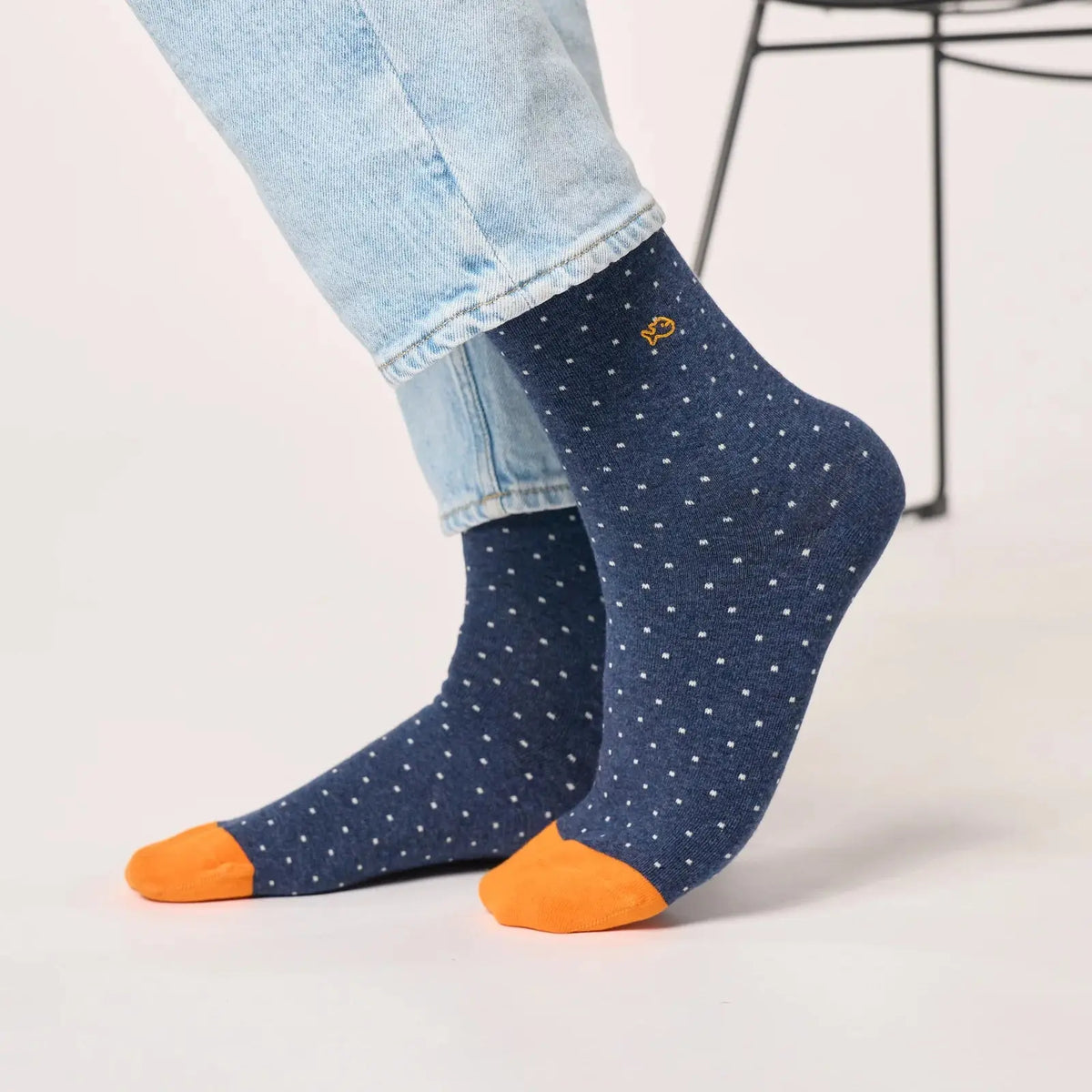 Paire Bleu Marine chiné à micro-carrés blancs portée de profil, pointes orange vif nettement détachées.