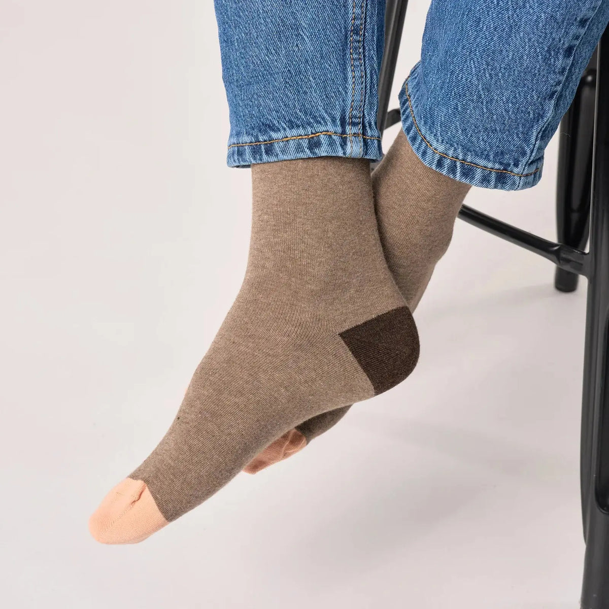 Chaussettes marron taupe portées avec un jean, talon chocolat et pointe pêche visibles