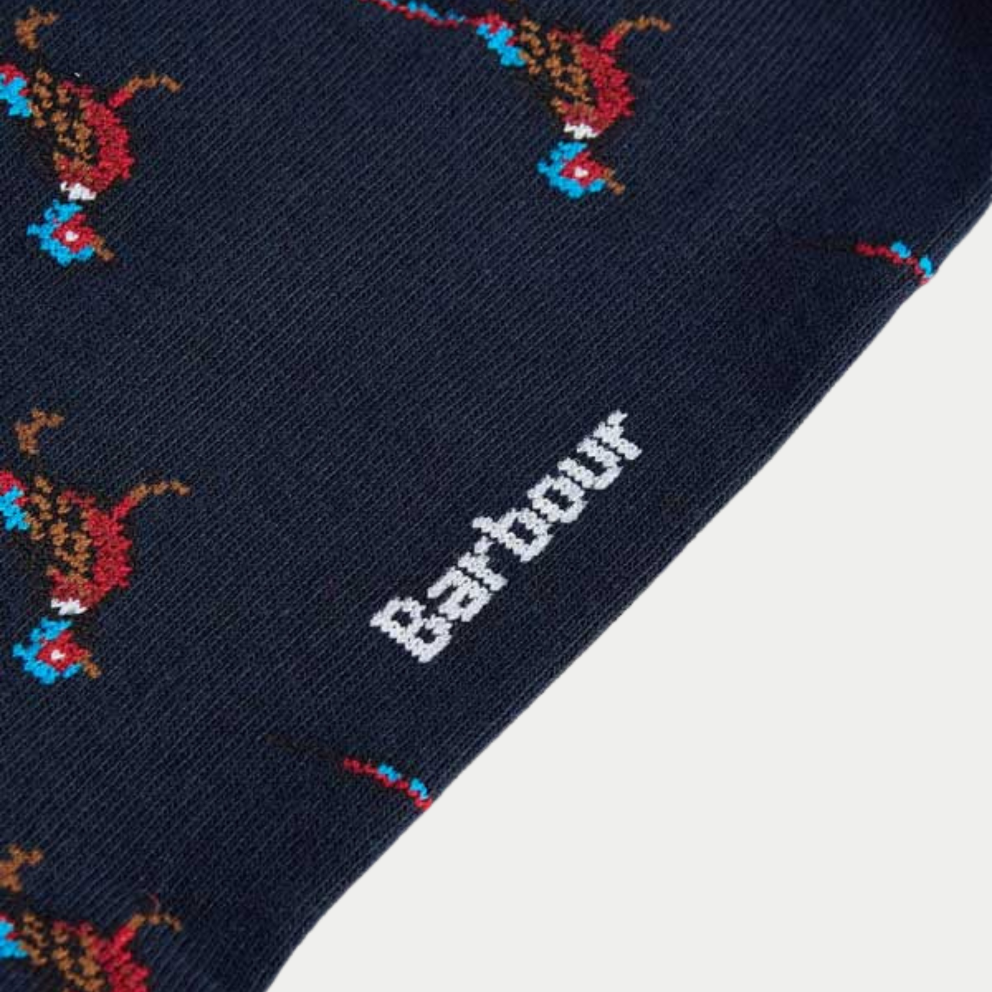 Gros plan sur la maille des chaussettes Mavin marine : faisan tricoté en intarsia et logo Barbour blanc