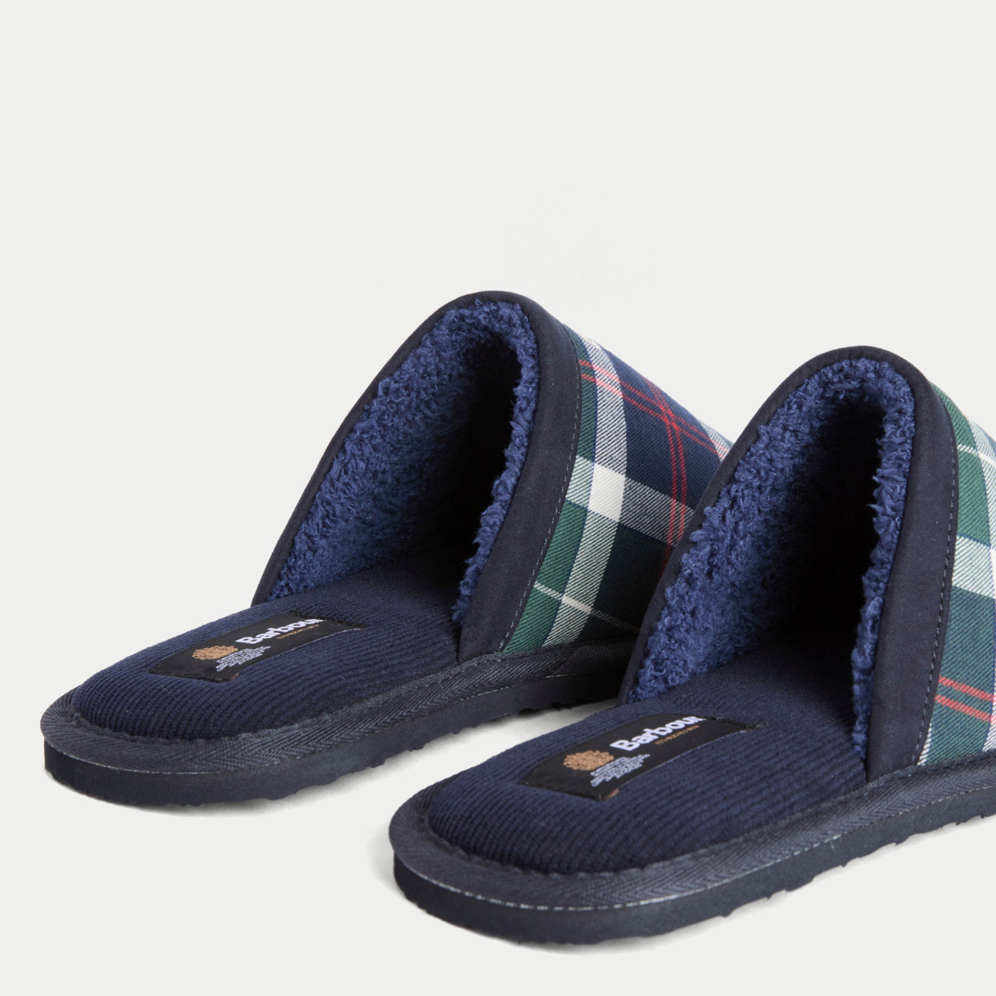 Détail des chaussons Everitt Tartan vert Barbour : première en velours côtelé marine, étiquette Barbour et doublure sherpa