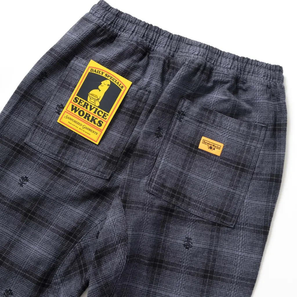 Poche arrière du Chef Pant et son étiquette jaune Service Works sur la flanelle à carreaux