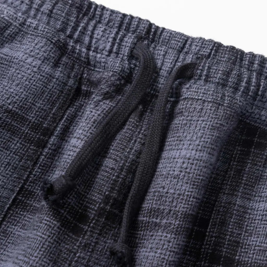 Macro de la flanelle grattée aux carreaux ombrés gris et noir, avec le cordon de serrage tressé
