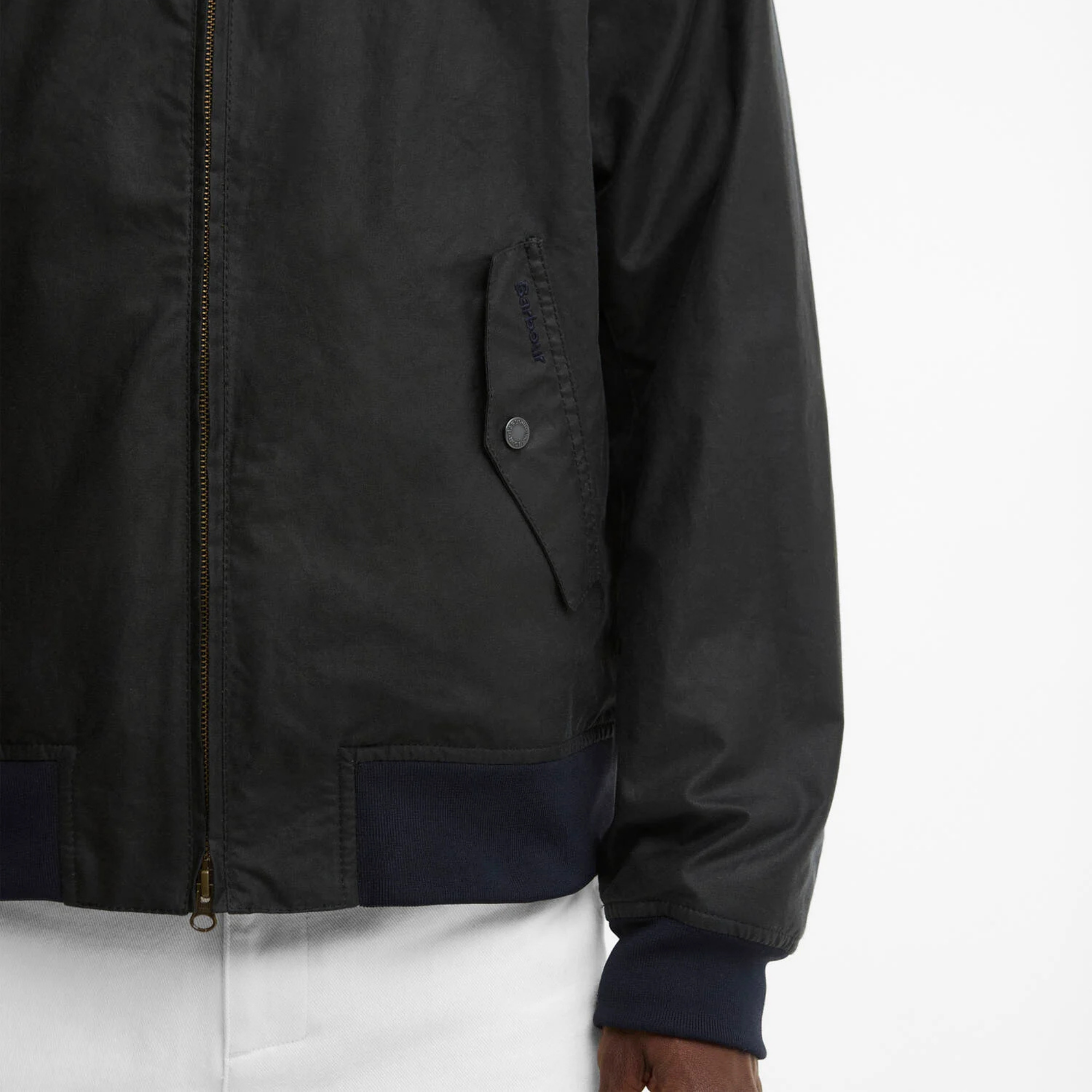 Détail du blouson ciré Chelsea Marine Barbour : poche à rabat pression et broderie Barbour ton sur ton