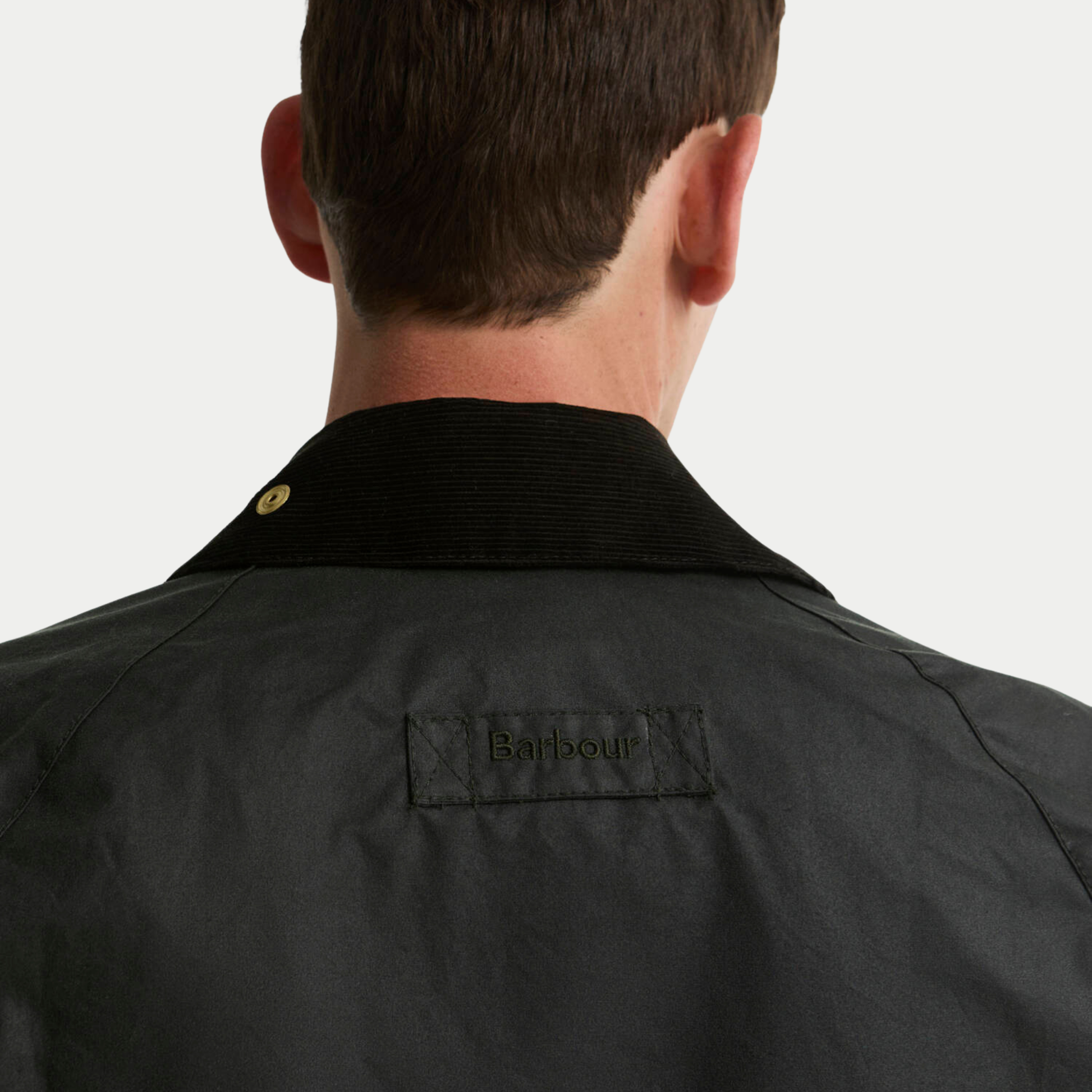 Détail de nuque de la veste Icons Bedale Patch Sage : col en velours côtelé relevé, étiquette Barbour brodée et pression laiton