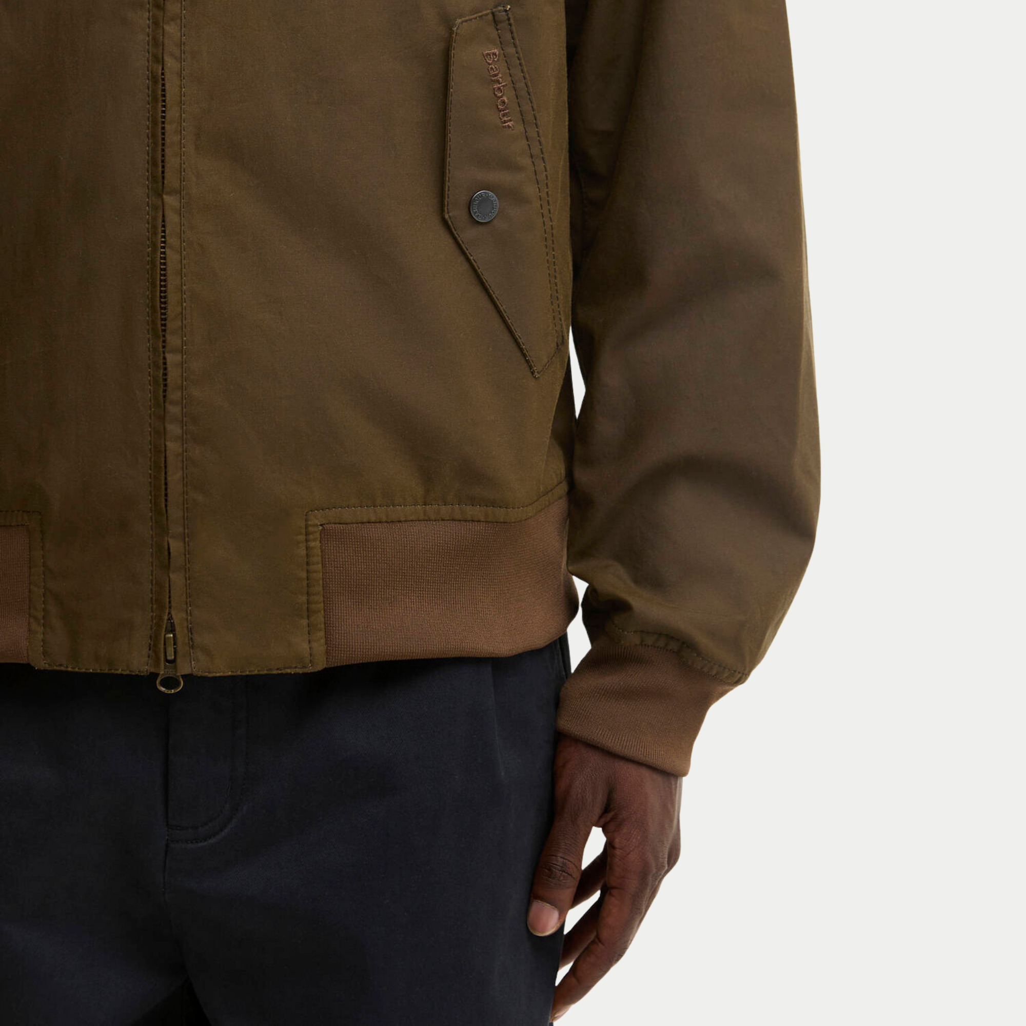 Détail du blouson ciré Chelsea marron Barbour : rabat de poche brodé ton sur ton, pression métal et bord-côte camel