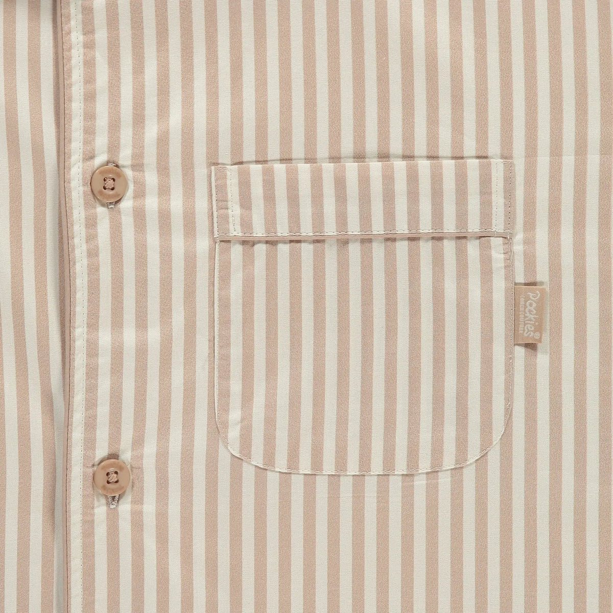 Macro du coton rayé beige : étiquette tissée Pockies, poche plaquée surpiquée et boutons ton sur ton
