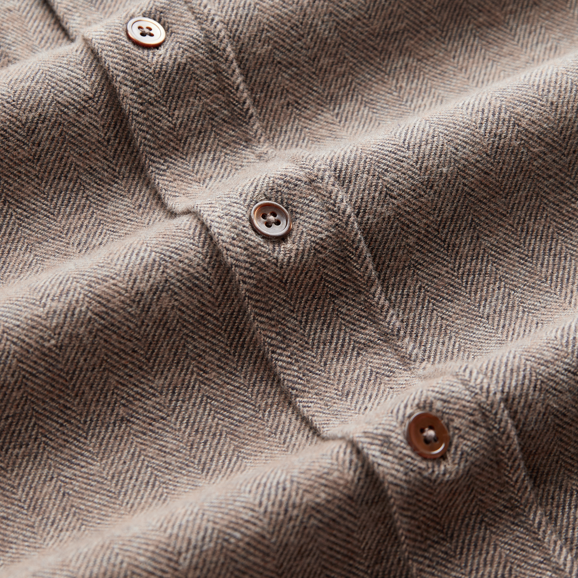 Chevrons bruns et écrus de la flanelle brossée et boutons de nacre