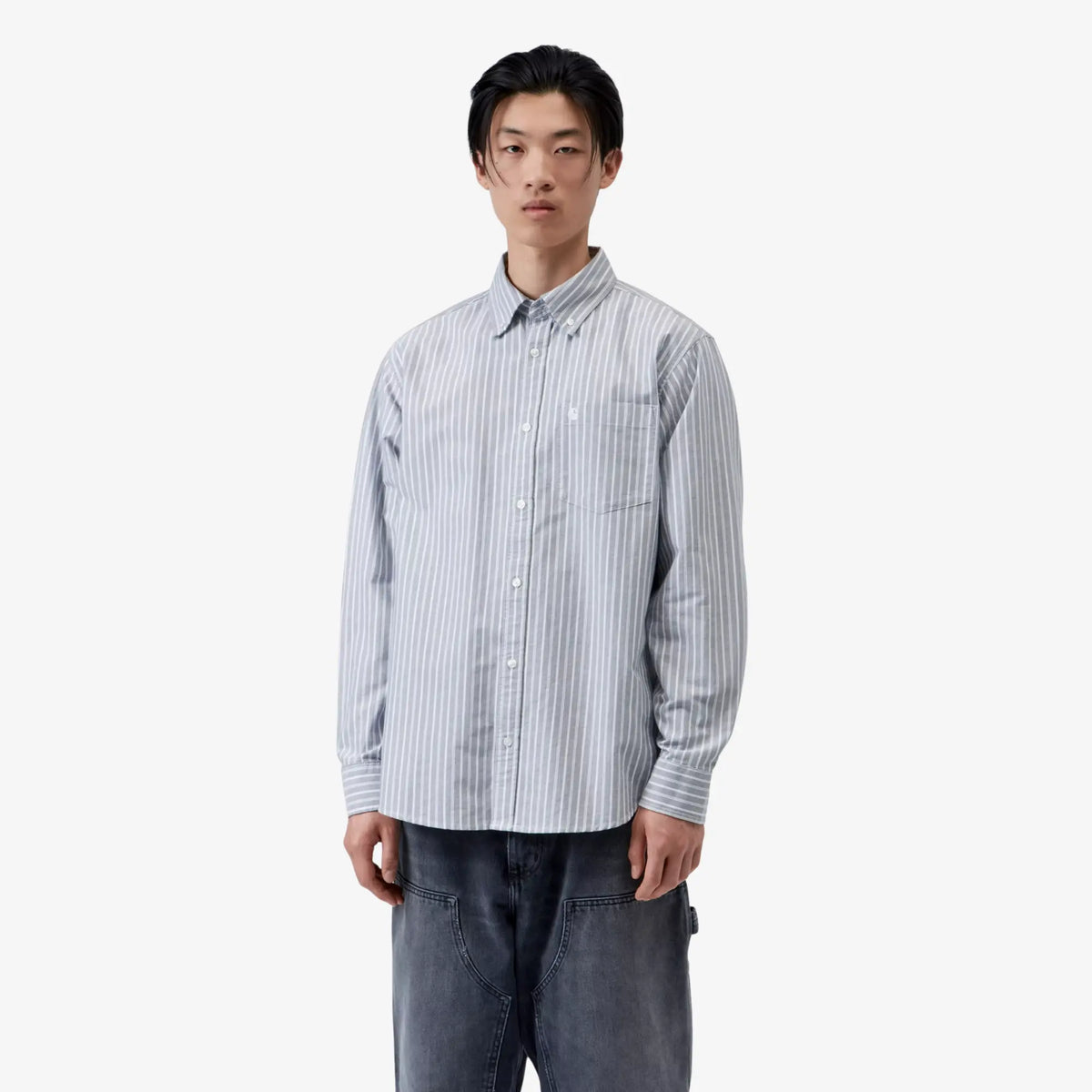 Chemise Kanan rayée gris et blanc portée de face, coupe loose, C brodé blanc sur la poche plaquée