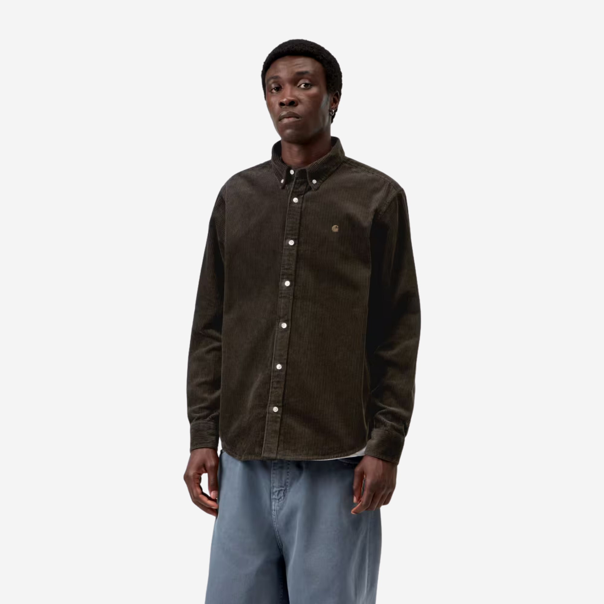 Chemise Madison velours côtelé marron foncé Carhartt WIP portée de face, col boutonné ouvert sur un t-shirt blanc