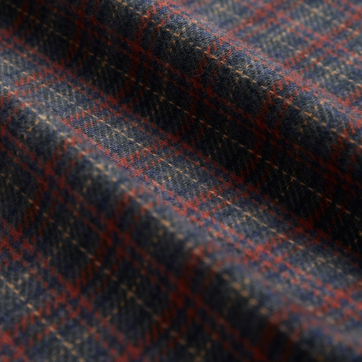 Gros plan de la flanelle brossée de la Chemise Plura, carreaux bleu marine, brique et fils beige