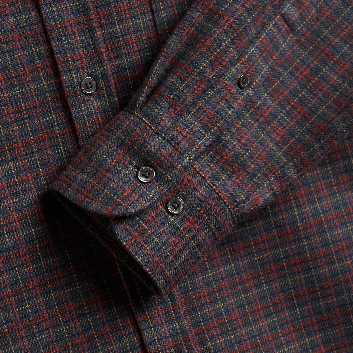 Poignet boutonné de la Chemise Plura, boutons foncés sur flanelle à carreaux bleu marine et brique