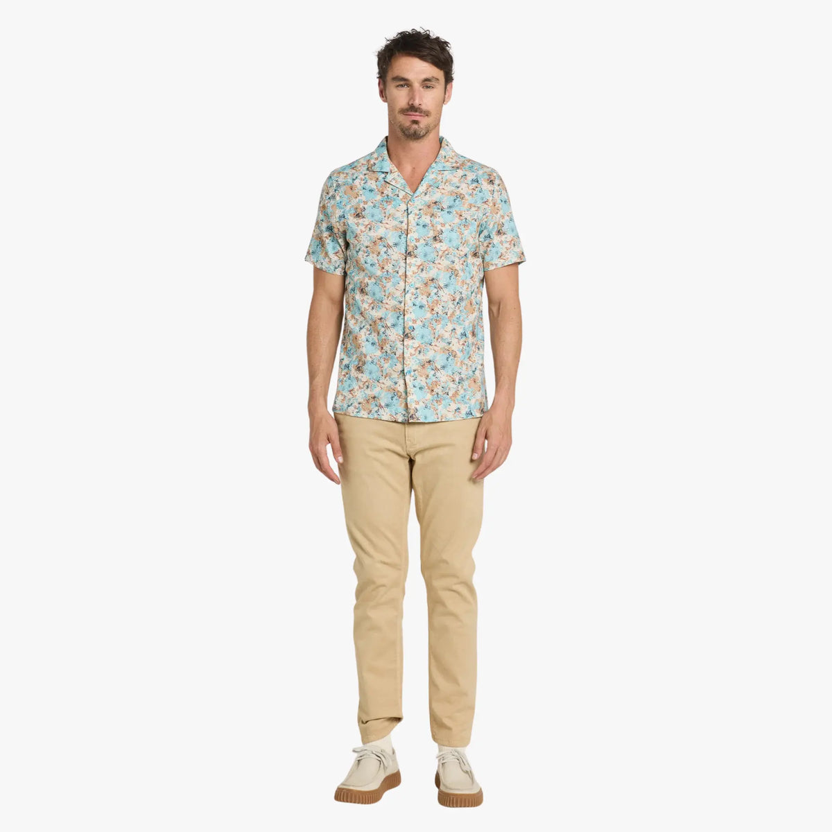Chino Dening Bisco beige sable porté de face avec une chemisette à fleurs turquoise