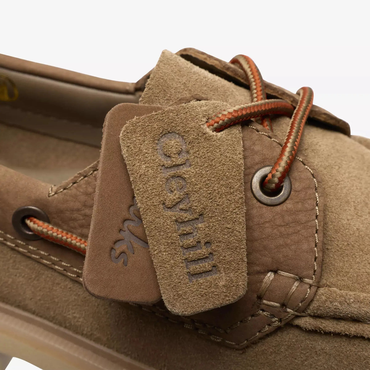 Macro des étiquettes cuir Cleyhill et du lacet bateau orange à œillet métal