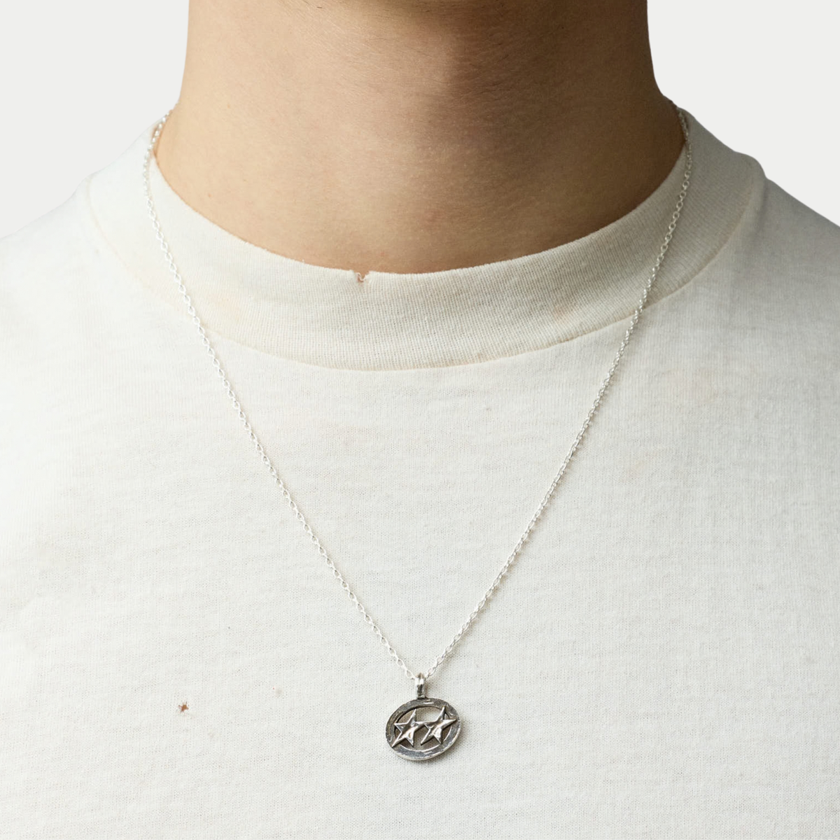 Collier Superstar Twojeys argenté porté sur un t-shirt écru